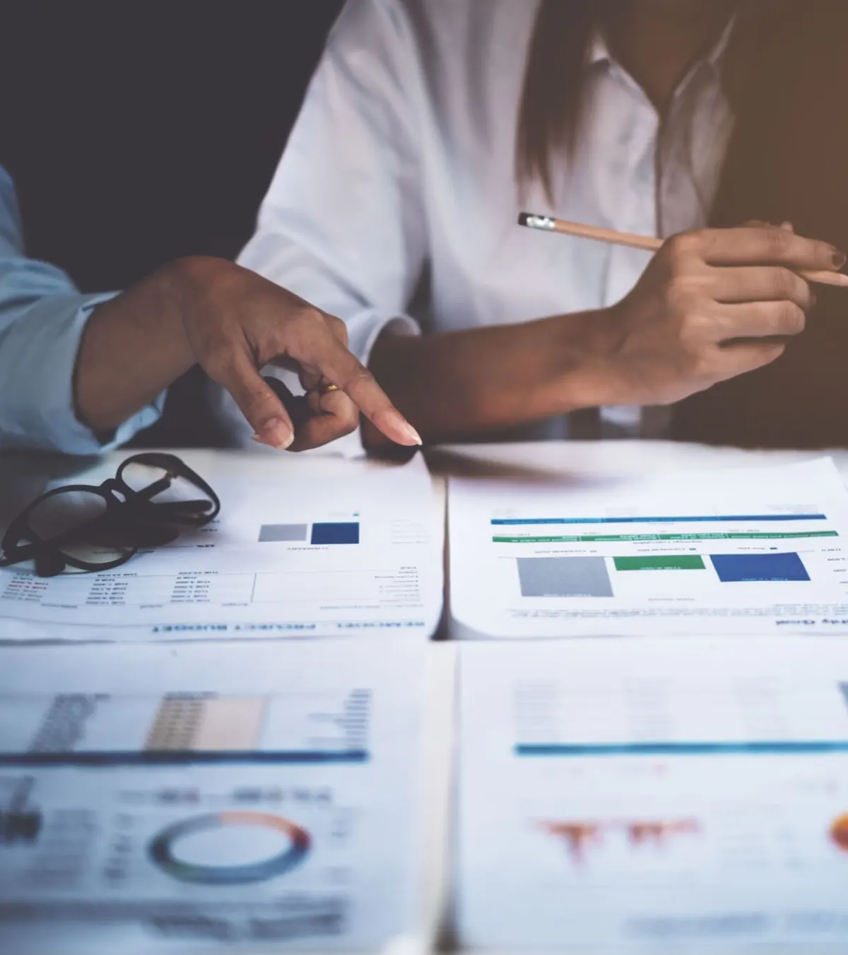 Deux personnes analysant des graphiques imprimés sur une table