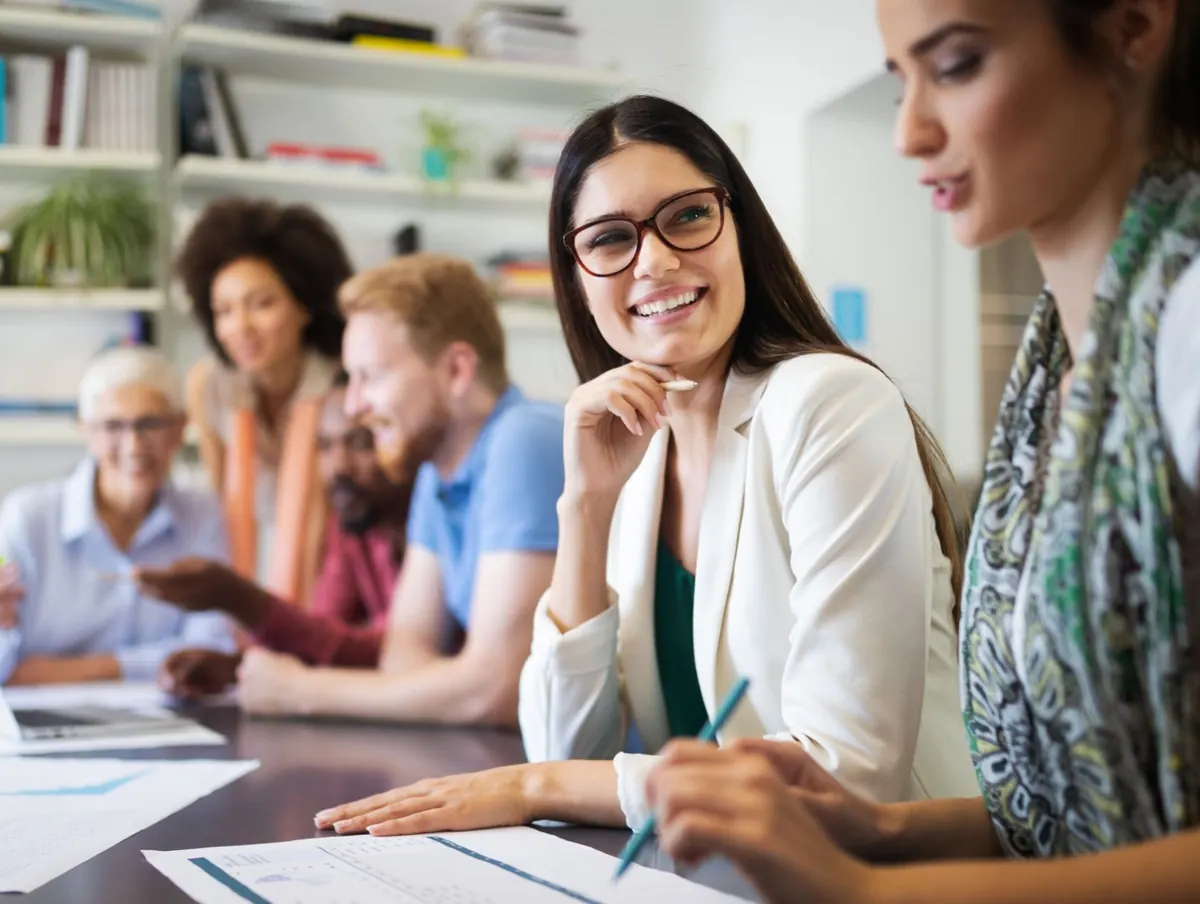 Une équipe souriante réunie autour d'une table de travail